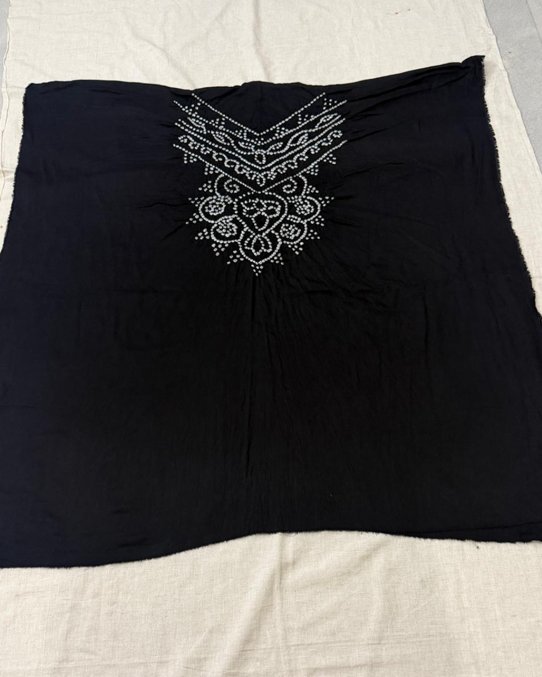 Black Bandhani top on a beige fabric background