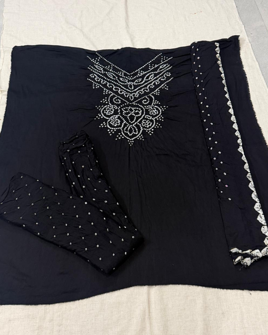 Black fabric with white embroidery on a beige surface