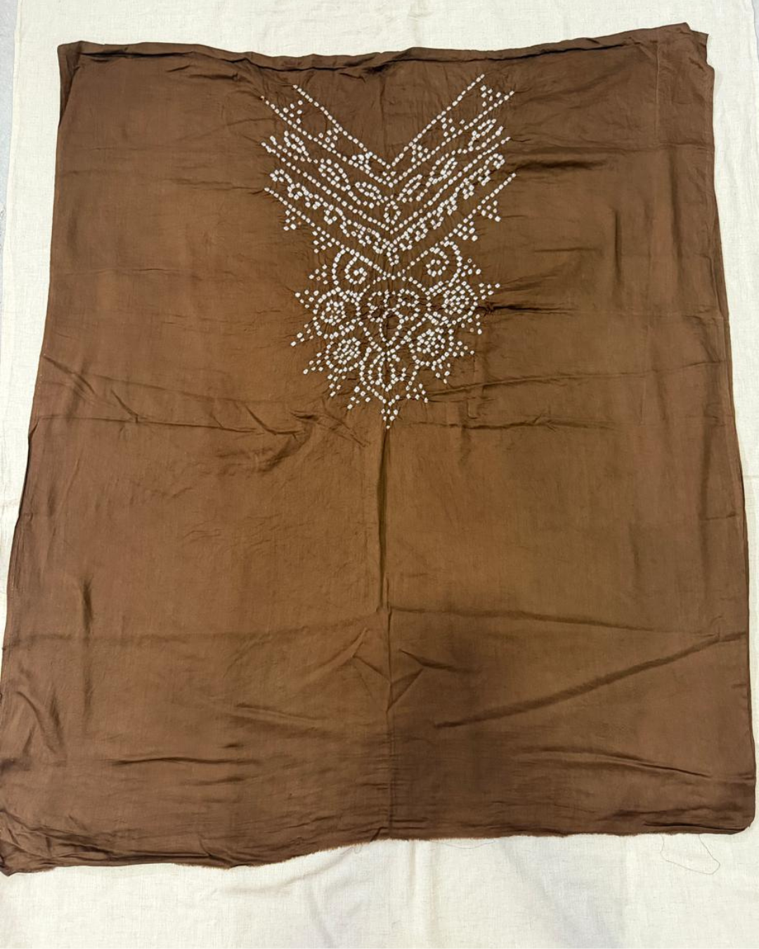 Brown bandhani fabric on a white background