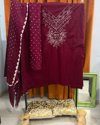 Maroon Bandhani fabric draped over a chair with a mirror in the background