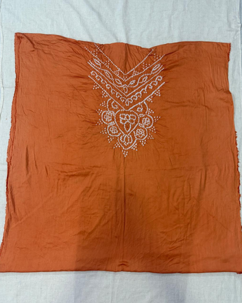 Peach fabric with white embroidery on a light gray background