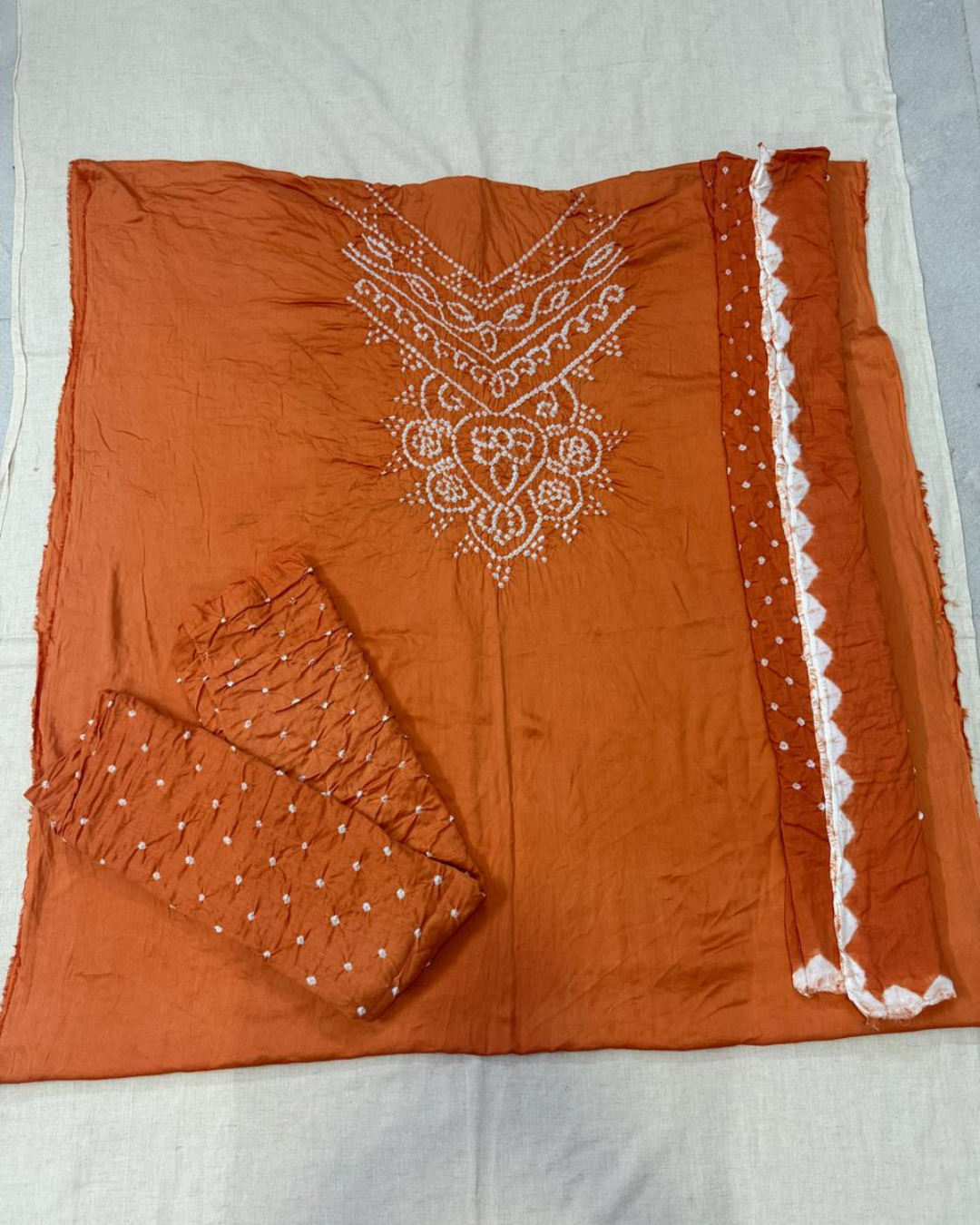 Peach fabric with white Handbandhej on a light gray background