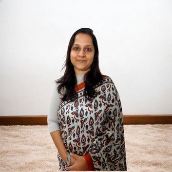 Woman wearing a Ajrakh Saree against a plain background