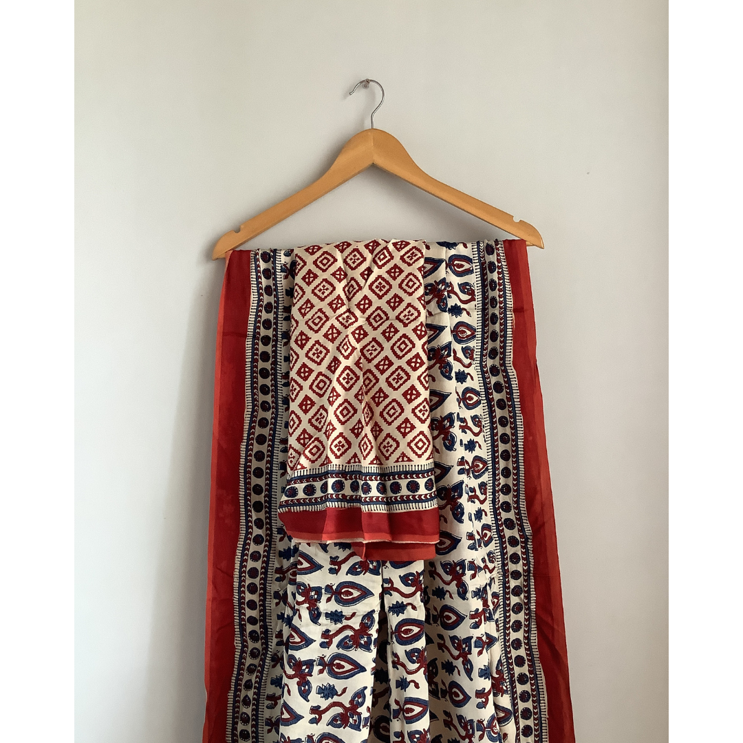 Ajrakh block print saree on a hanger against a plain wall