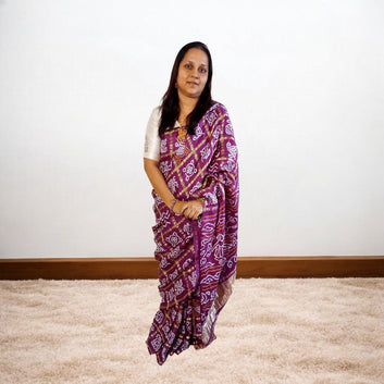 Woman wearing a purple saree with a white background