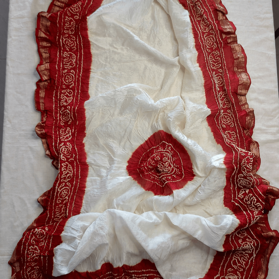 White fabric with red bandhani border on a white background