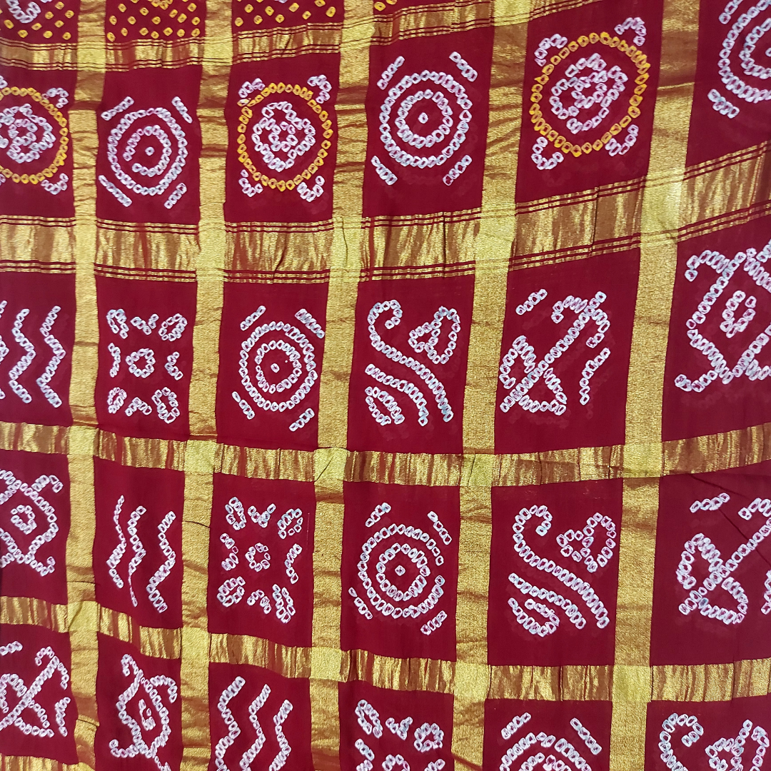close up of maroon gharchola bandhani blouse piece with white and yellow bandhej