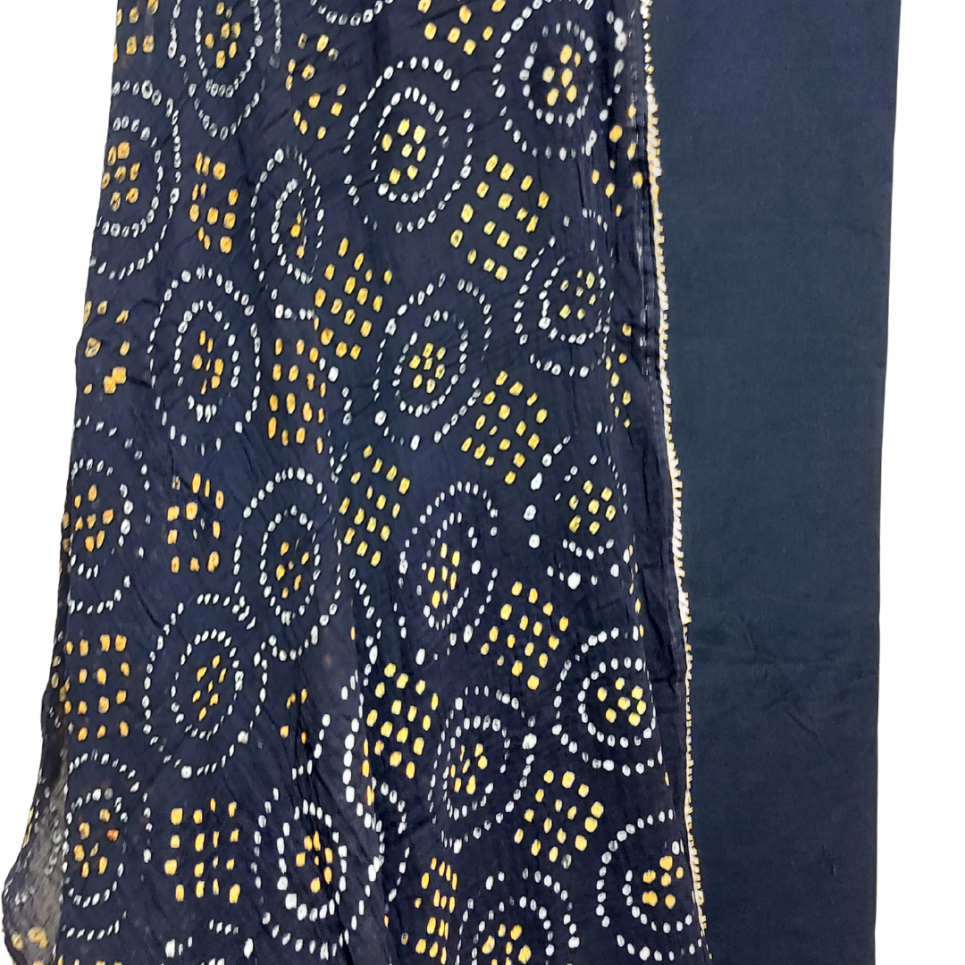 black bandhani dupatta with white and yellow bandhej on flowing on plain black fabric with white background