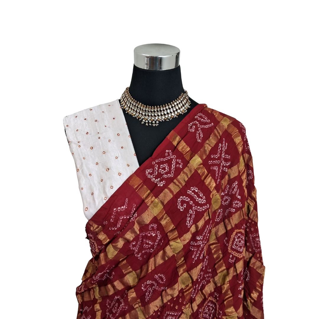 handloom cotton Red gharchola bandhani saree with a white blouse on a mannequin against a white background
