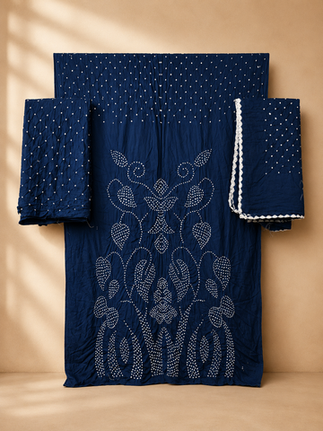 A indigo blue traditional outfit set with intricate white embroidery and dotted patterns, displayed against a warm beige background with soft shadow overlays.