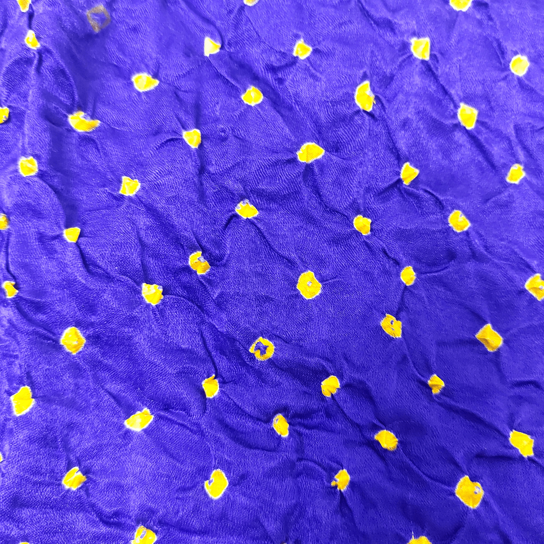 close up of yellow bandhej on indigo fabric