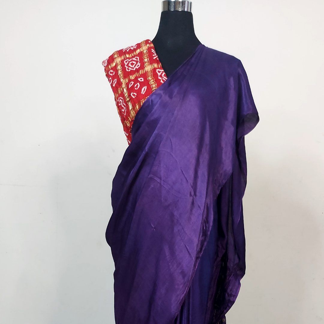 Purple saree with a maroon patterned blouse on a mannequin against a white background