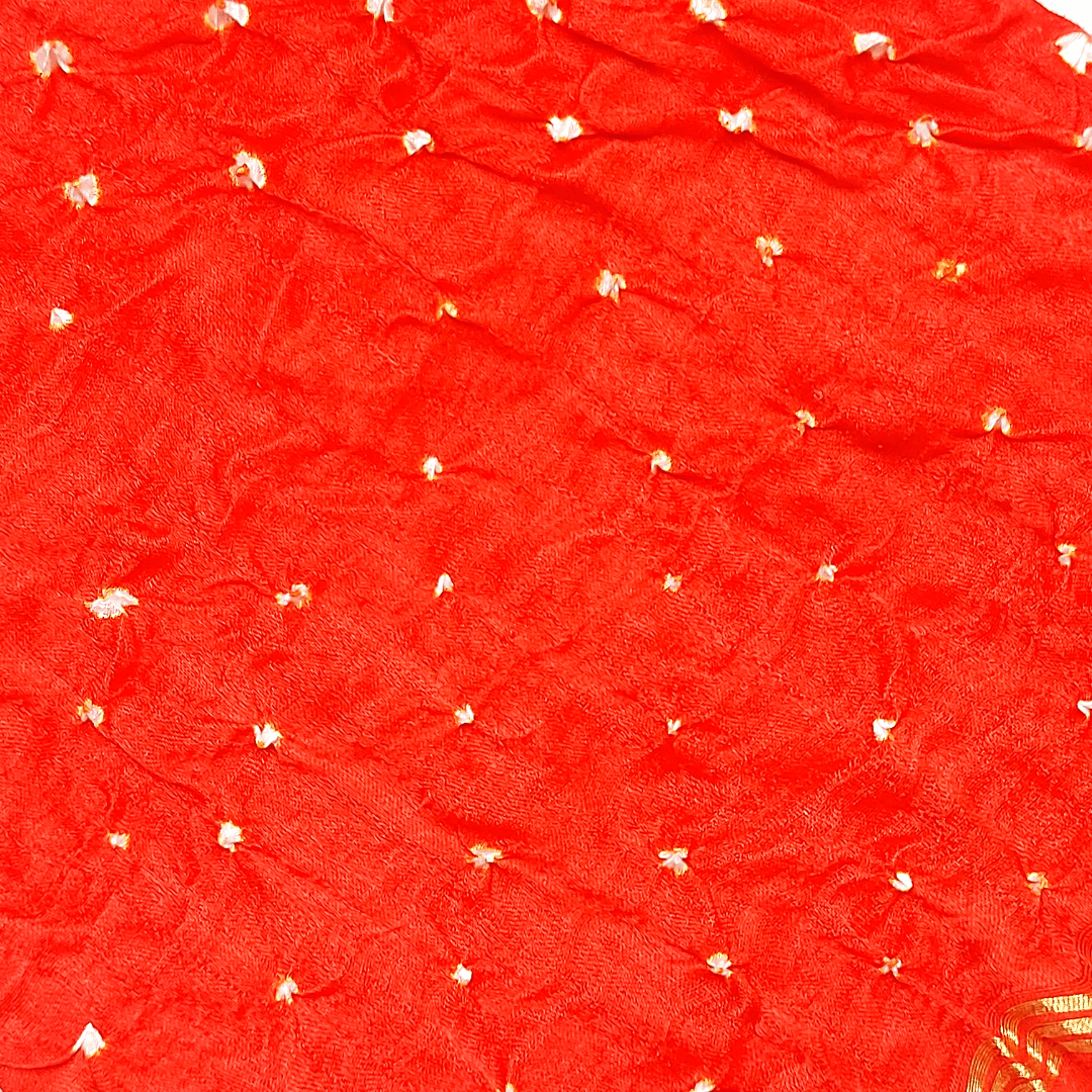close up of white dana bandhej on orange fabric