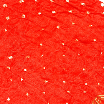 close up of white dana bandhej on orange fabric