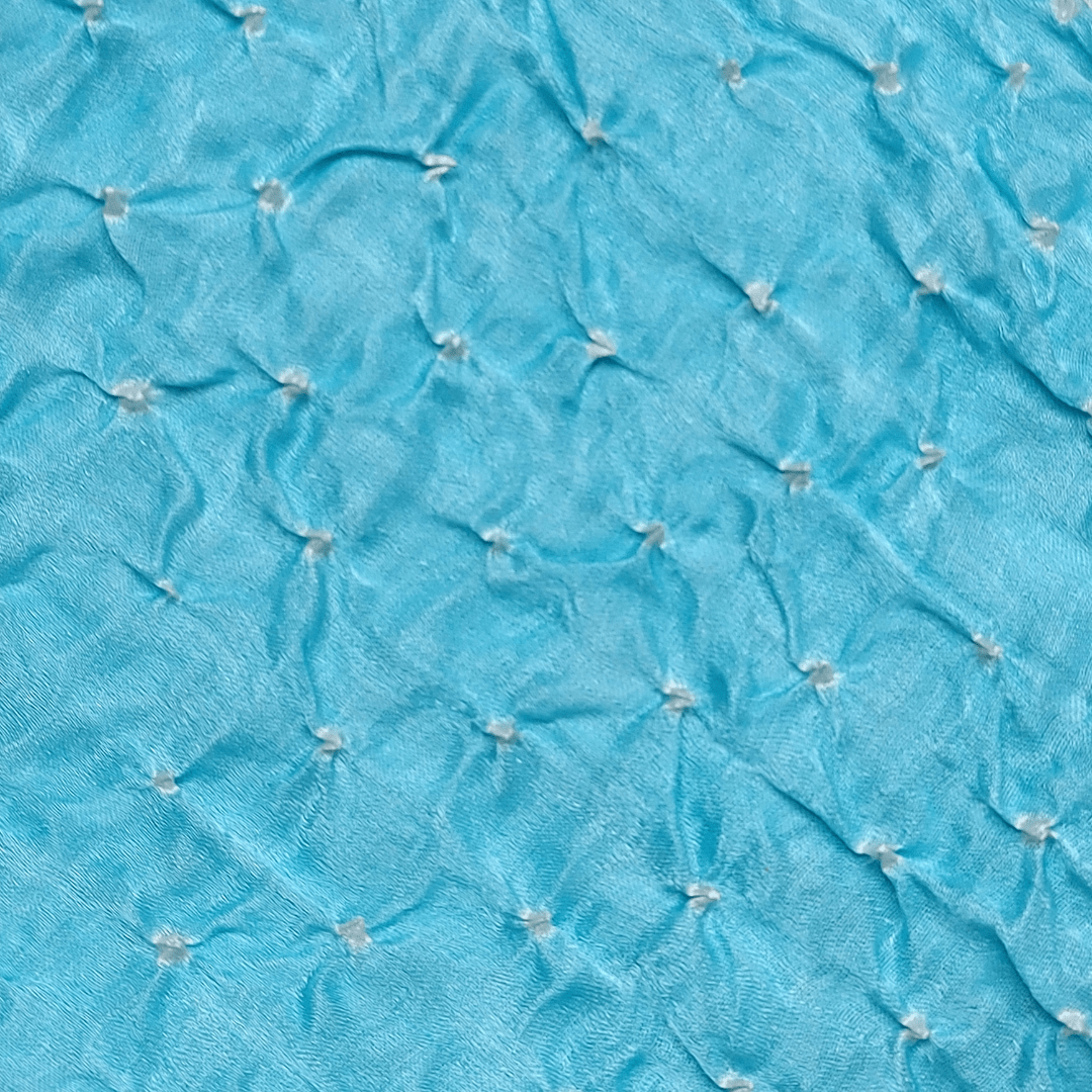 close up of white dana bandhani on pastel blue