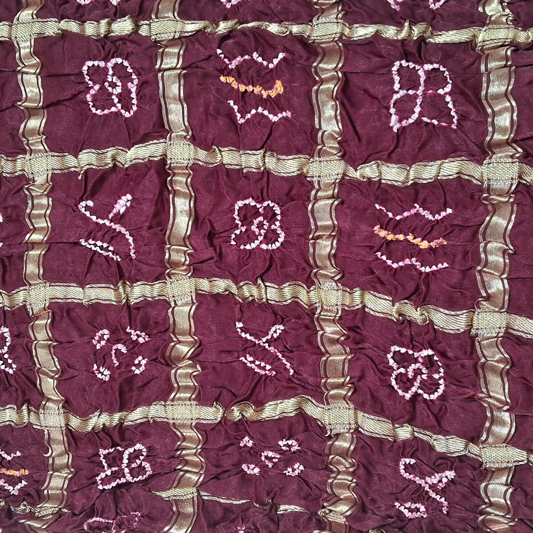Close-up of a dark maroon gharchola bandhani blouse piece