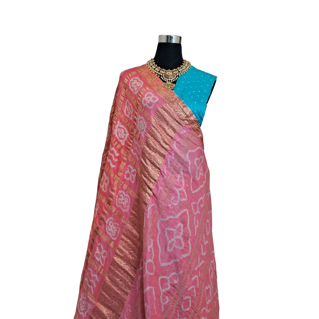 pink pure gajji silk gharchola bandhani saree Saree with blue blouse piece draped over a mannequin on a white background