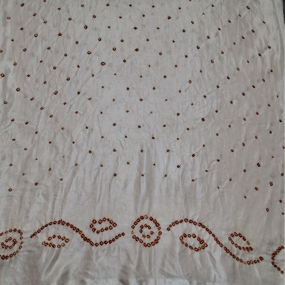 close of red bandhani on pure gajji silk white fabric