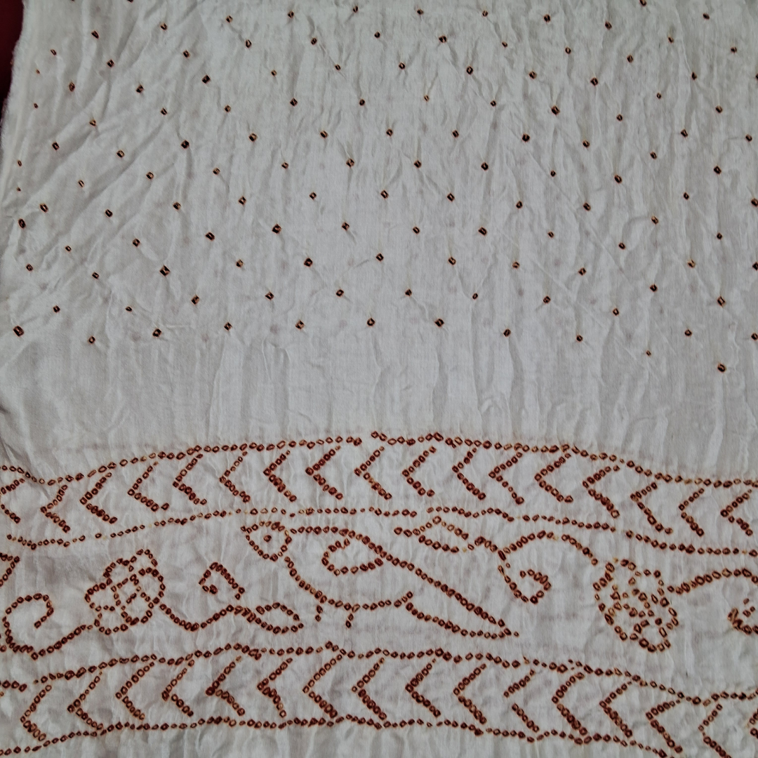 close of red bandhani on white pure gajji silk blouse piece