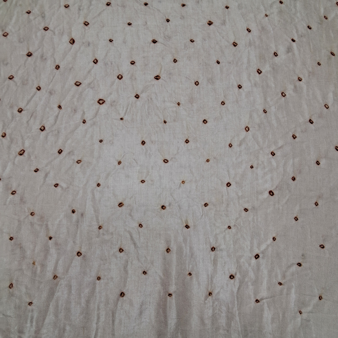close up of red dana bandhej on white pure gajji silk blouse piece