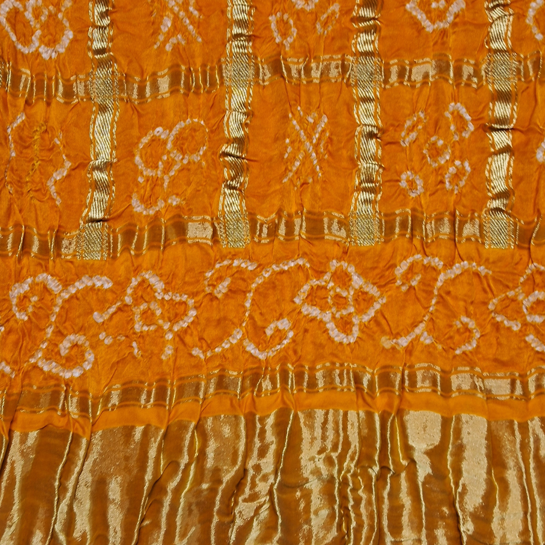 Close-up of orange pure gajji silk gharchola bandhani blouse piece with white bandhani design