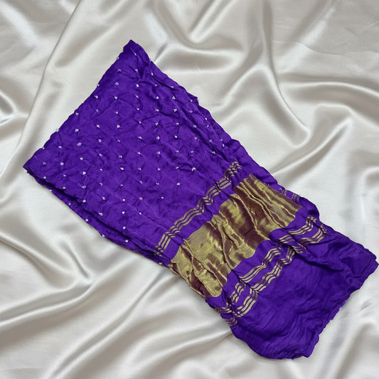 purple bandhani blouse piece on offwhite satin background