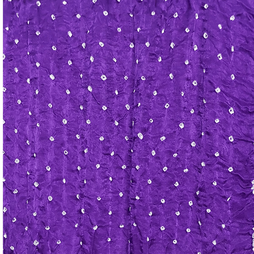 close up of white bandhej on purple fabric