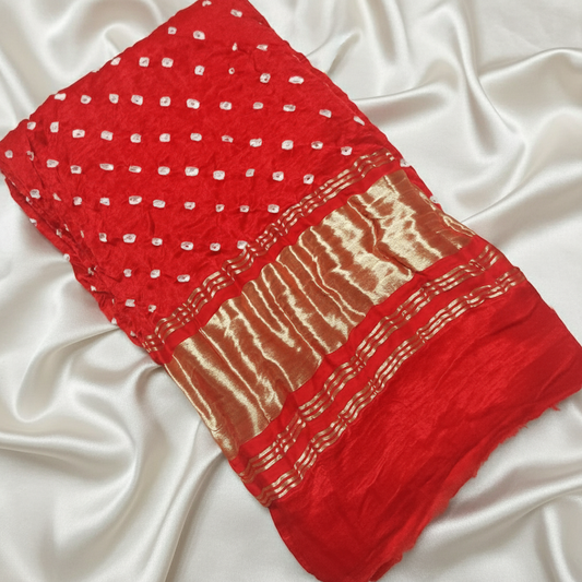 red bandhani blouse piece on off white satin background