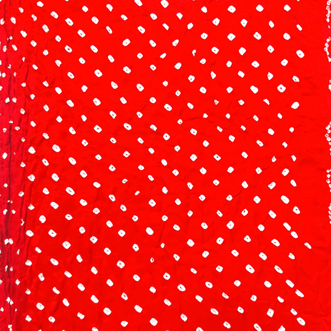 close up of white bandhej on red fabric