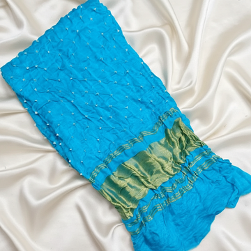 Blue fabric with golden border on a white satin background