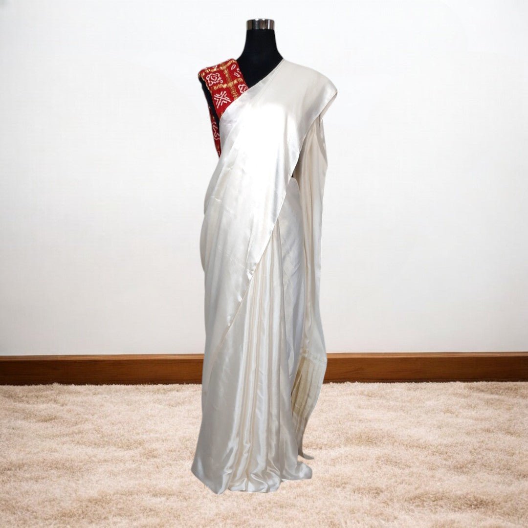 White saree with red blouse on a mannequin against a white background