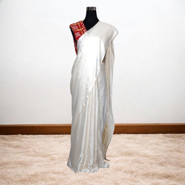 White saree with red blouse on a mannequin against a white background