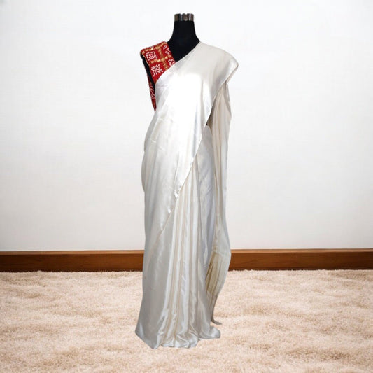 White saree with red blouse on a mannequin against a white background