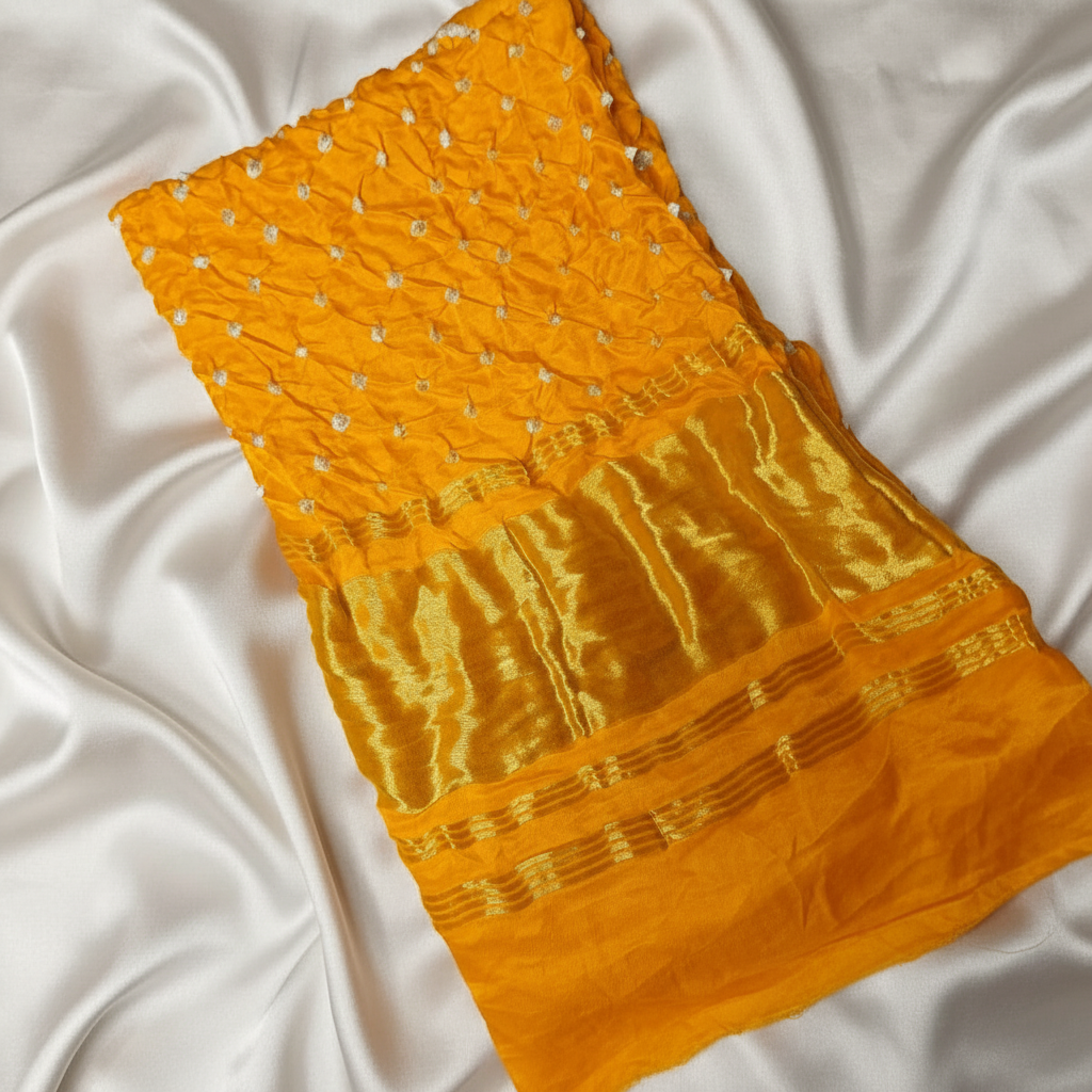 Yellow bandhani blouse piece on a white background