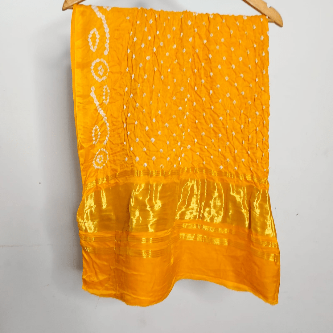 yellow bandhani blouse piece on a hanger 